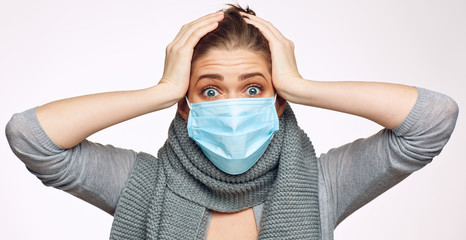 Scared woman wearing medical mask isolated studio portrait