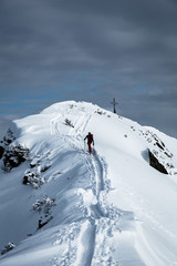Naklejka na ściany i meble Sportler erreicht Gipfel bei einer Skitour im Winter