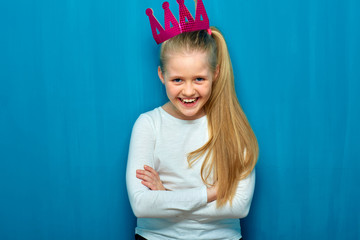 Little laughing girl wearing pink crown.
