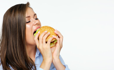 Portrait of young woman eating fast food burger.