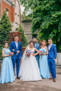 beautiful newlyweds with their friends having fun together. Friendship picture. Bridesmaids and groomsmen with bride and groom. Drinking champagne.