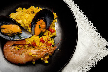 Traditional rice in paella with fish and meat.