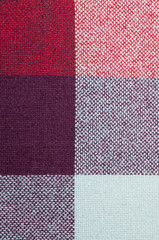 Textured fabric with a pattern of squares of shades of red and purple