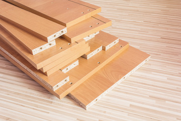 Wooden boards planked on the floor. Furniture material made of chipboard. Home assembling furniture.