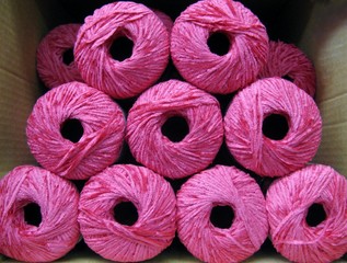 Set of bright pink rayon chenille yarn balls in a carton box