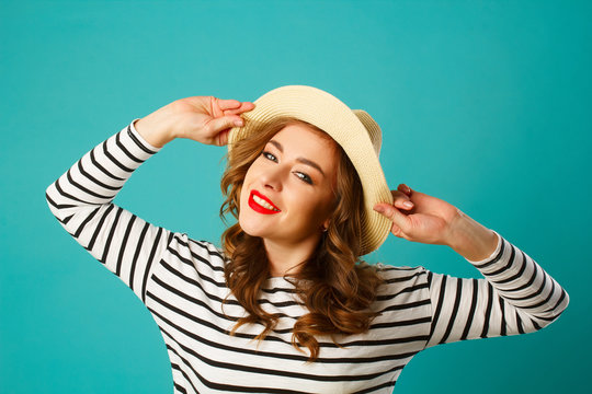 Portrait of young beautiful smiley blond woman in hat over blue background