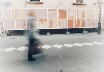 isolated blurry person walks in town