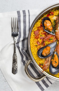 Traditional rice in paella with fish and meat.