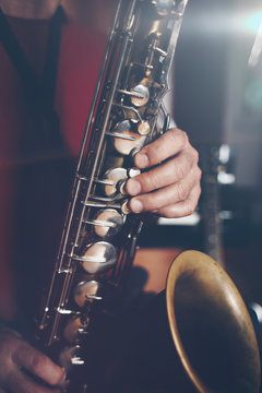 Close up shot of musician playing saxophone. Low light and selective focus.