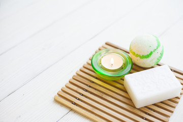 Aromatherapy spa concept with soap bars, ball of sea salt, candle on wooden bars carpet, closup