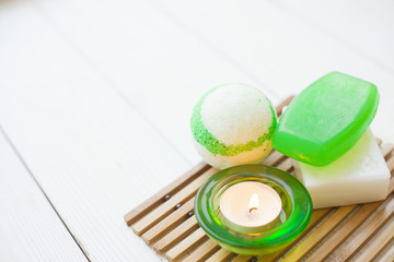 Aromatherapy spa concept with soap bars, ball of sea salt, candle on wooden bars carpet, closup