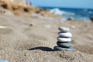 Fototapeta na wymiar Balance of stones on the beach, sunny day