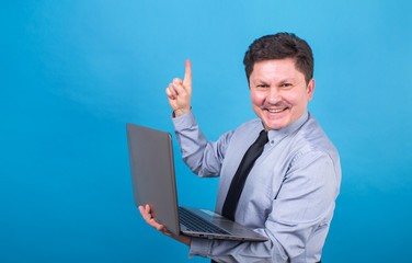 Business man is holding a laptop in his hands and showing his finger up.