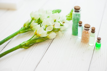 Obraz na płótnie Canvas Aromatherapy spa concept with essential oil in glass bottles, flowers on white wooden board, instagram