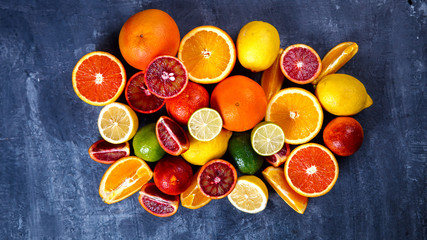Different Citrus Fruit on a Blue Background .Mixed Colorful Tropical Background.Food or Healthy diet concept.Vegetarian.Toned image.Copy space for Text. selective focus.