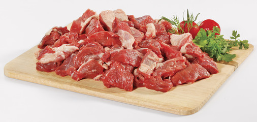 fresh raw red cubed meat chunk on wooden cut board isolated over white background
