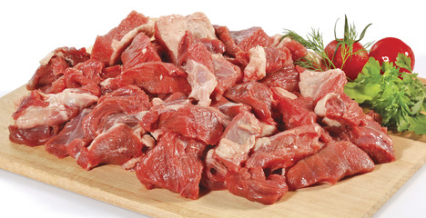 fresh raw red cubed meat chunk on wooden cut board isolated over white background
