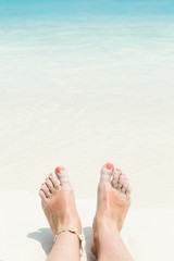 Woman legs on beach in sea wave