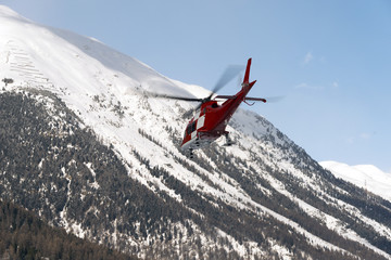 A rescue helicopter in the snowy alps switzerland in winter