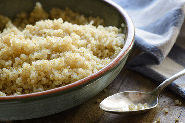 Quinoa in a geen bowl with a spoon and a napkin