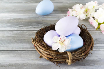 Easter eggs in nest on wooden background