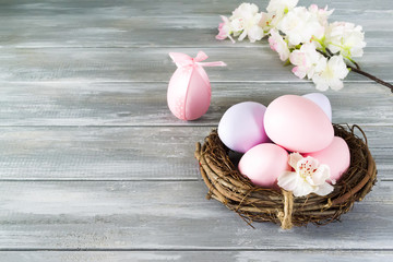 Easter eggs in nest on wooden background