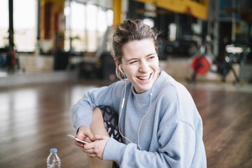Young woman in the gym with Smartphone
