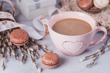 Pink coffee mug with sweet pastel french macaroons, gift box and pussy willow