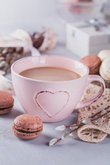Pink coffee mug with sweet pastel french macaroons, gift box and pussy willow