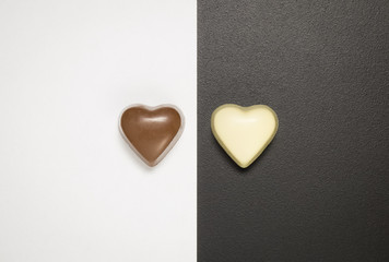 Obraz premium Top view of heart shaped chocolate bars on black and white