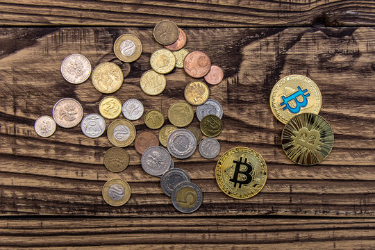 bitcoins and simple coins lie on wooden table