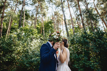 the brides are hiding behind a bouquet in the forest