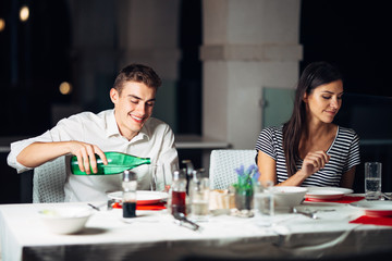 Smiling woman on a date in a restaurant,having a conversation over a meal in hotel.Cheerful female customer drinking coffee with a partner.Positive emotions,love,affection.Public place behave manners