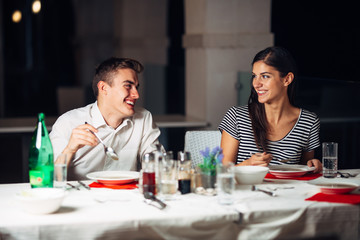 Smiling woman on a date in a restaurant,having a conversation over a meal in hotel.Cheerful female customer drinking coffee with a partner.Positive emotions,love,affection.Public place behave manners