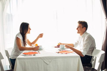 Happy couple at restaurant eating lunch.Talking over meal.Hotel full board,all inclusive stay.Travel, date,food,lifestyle.Smiling people having healthy breakfast.Food review.Manners at the table
