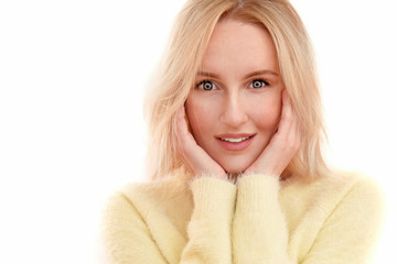 Beautiful blonde woman with a kind smile and eyes, clean  natural skin in a yellow sweater isolated on a white background