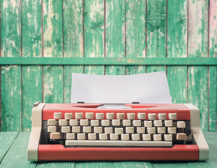 Red typewriter on a green background