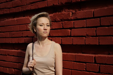 Fototapeta na wymiar woman on the background of red brick wall