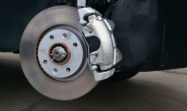 Close-up of a disc brake with caliper during tyre replacement. Car maintenance.