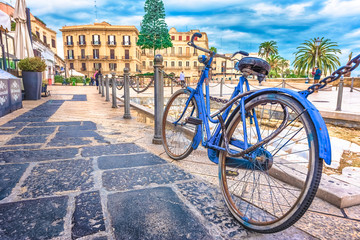 Fototapeta na wymiar Old blue bicycle with the old town in the background