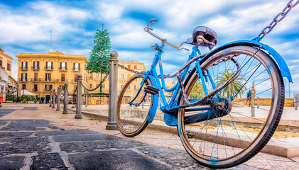Fototapeta premium Old blue bicycle with the old town in the background