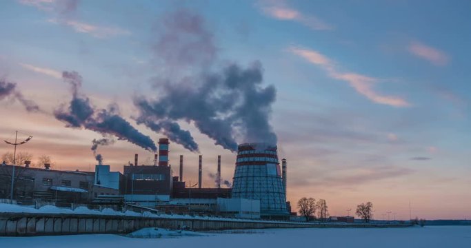 Cogeneration power plant in city. Sunset landscape. Combined heat and power plant near megapolis. Chimney-stalk and ecology problem on Earth. Heat electricity.Time lapses