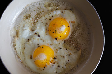fried eggs from 2 eggs in a frying pan. Hot Sunny dish