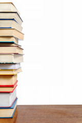 A stack of different books on a table against