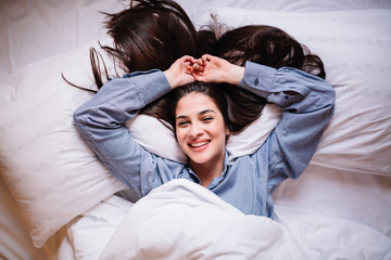 Portrait of an attractive young brunette in bed after wake up.