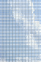 Spiegelfenster mit Wolkenreflektionen / Die Fassade eines modernen Bürogebäudes mit...