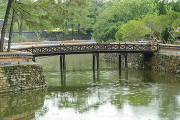 Fototapeta na wymiar bridge in the pond inside the complex of the mausoleum of the emperor Tu Duc in Hue, Vietnam.