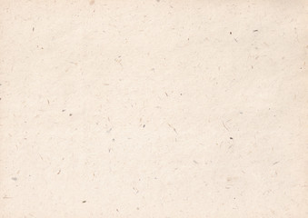 texture of light kraft paper sheet with soft dark brown grain shavings