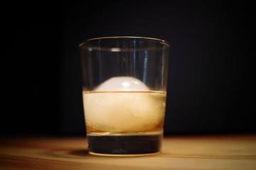 Whiskey with an ice ball in the glass. Selective focus