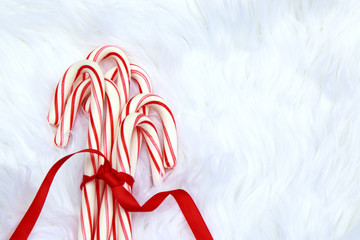 Red and White Candy Canes on Furry White Background